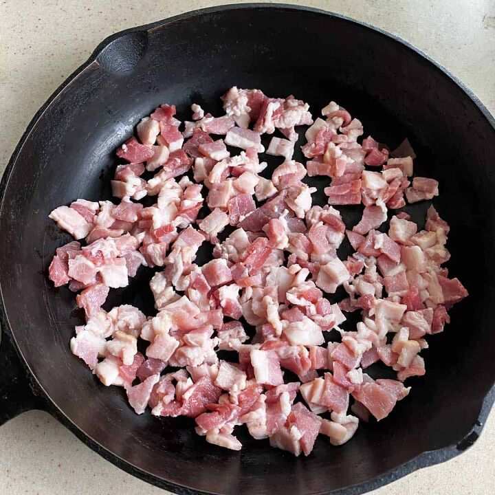 smoked baked beans with bacon and brown sugar, Chopped raw bacon in a black cast iron skillet