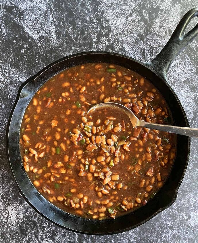 smoked baked beans with bacon and brown sugar, Stirring the beans into the onion jalapeno mixture in a large cast iron skillet