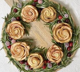 baked apple rose wreath, Baked apple roses on a round wood cutting board with rosemary and cranberries around them to make them look like a wreath
