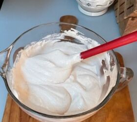 glass mixing bowl of whipped cream and cheesecake mixture