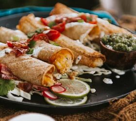 air fryer cheesy potato taquitos, Plate with several air fried potato stuffed taquitos a cream in the foreground and topped with quick pico
