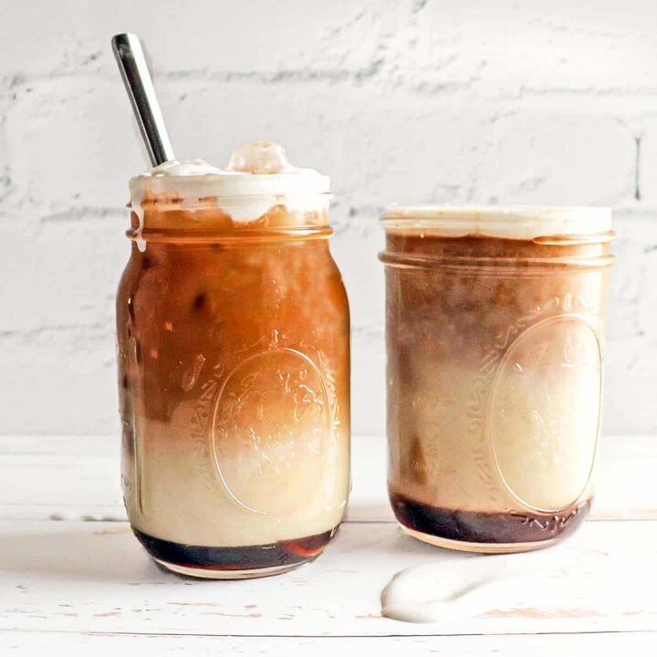 Two mason jars filled with apple crisp macchiato topped with sweet cream