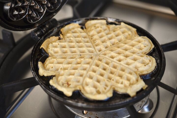 easy cast iron sourdough waffles, sourdough waffle in cast iron waffle maker on stove top