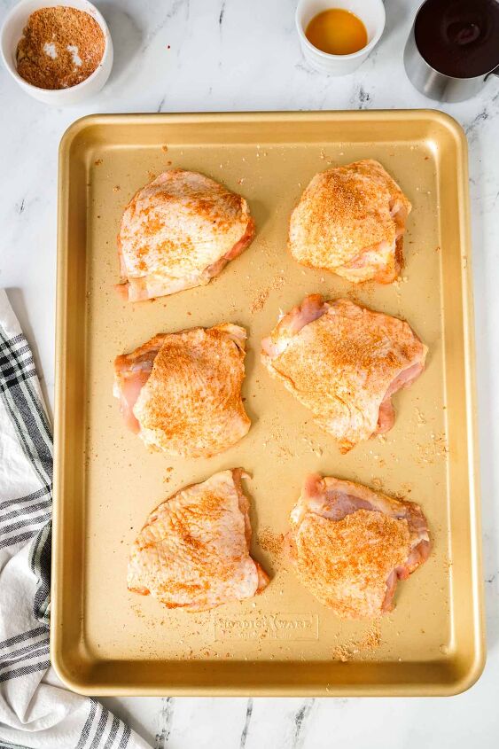slow cooker bbq chicken thighs, Chicken thighs on a baking sheet coated with a spice rub