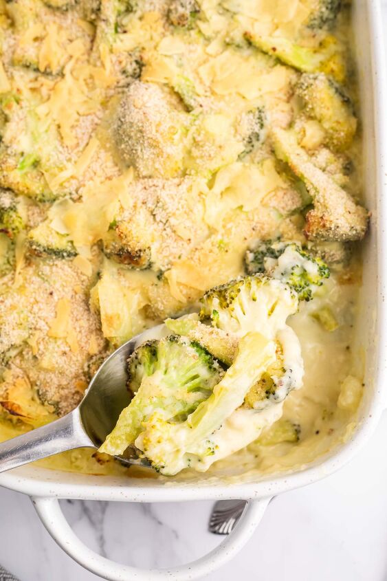 cheesy broccoli au gratin recipe, Cheesy Broccoli Au Gratin in a pan being scooped out with a spoon