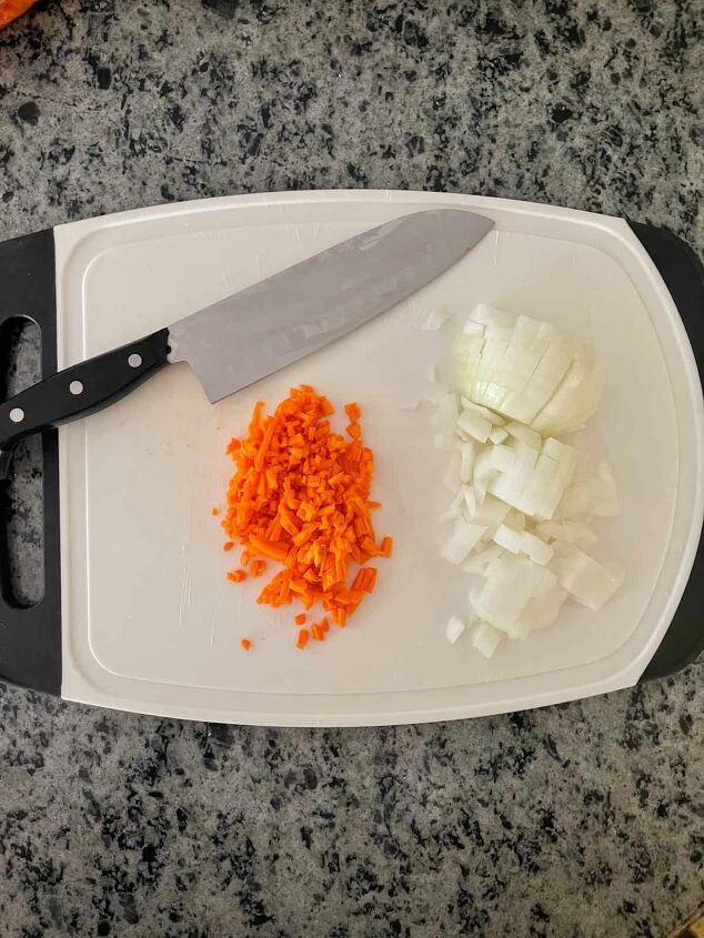 the best creamy pumpkin soup recipe, chopping onions and slicing carrots to make creamy pumpkin soup