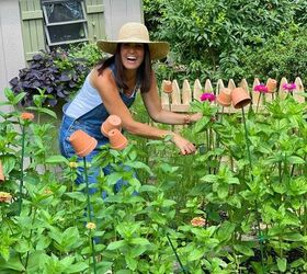the best creamy pumpkin soup recipe, Home and Garden Blogger Stacy Ling cutting zinnia flowers in her cottage garden with wood picket fence in front of garden shed