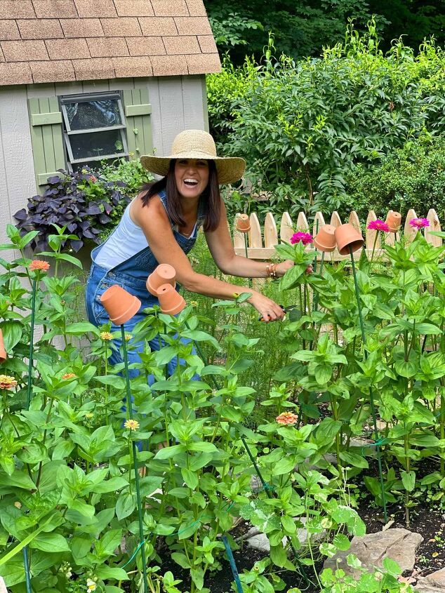 the best creamy pumpkin soup recipe, Home and Garden Blogger Stacy Ling cutting zinnia flowers in her cottage garden with wood picket fence in front of garden shed