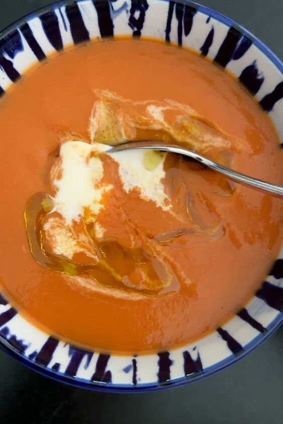 Creamy tomato soup garnished with cream and olive oil