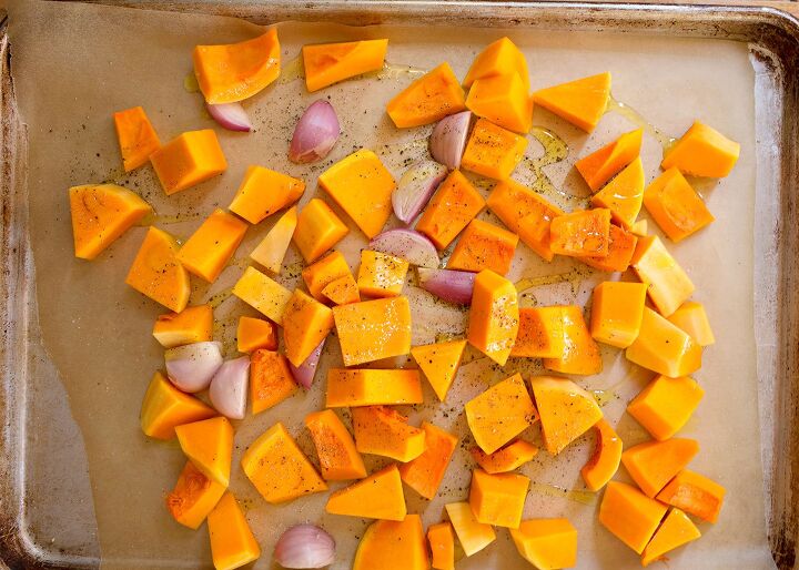 roasted butternut squash soup, Chunks of squash and shallots on a parchment lined baking dish