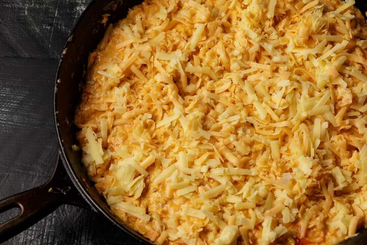 easy buffalo chicken dip recipe, An iron skillet with chicken dip topped with cheese