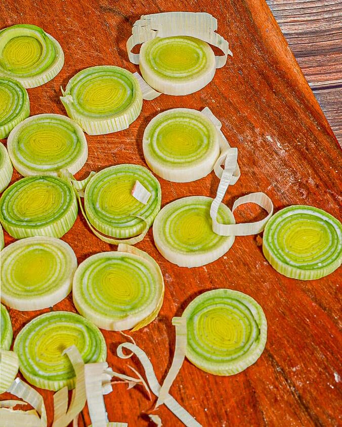 how to dehydrate leeks, close up of sliced dried leek rings on a red brown wooden board