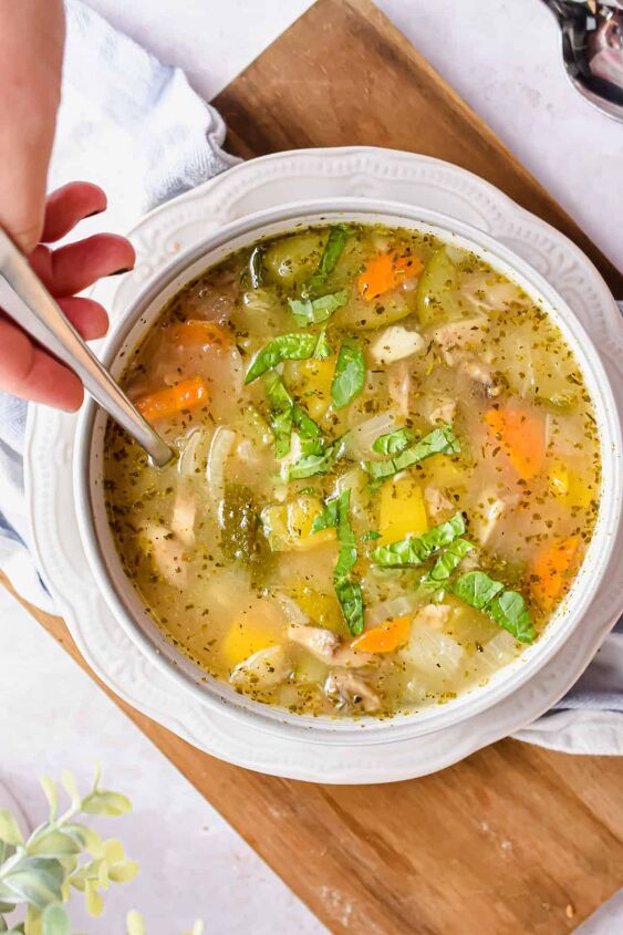 simple instant pot vegetable barley soup, An overhead shot of the soup with a hand holding the spoon