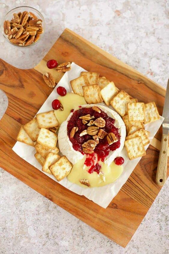 baked brie with cranberry sauce, baked brie with cranberry sauce and pecans on a cutting board