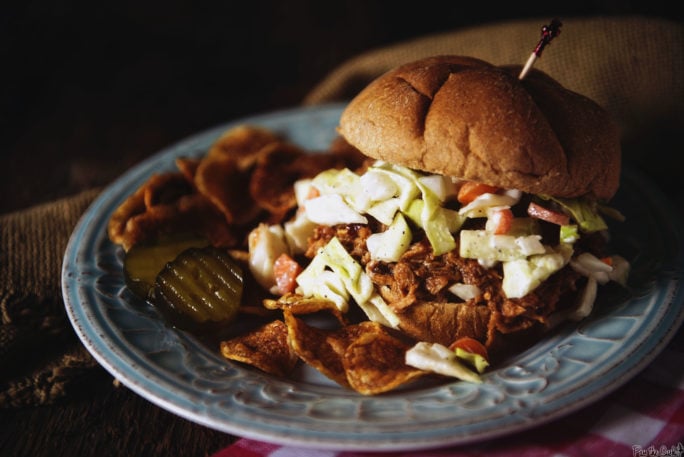 easy slow cooker pulled pork kita roberts girl carnivore, Pulled pork and coleslaw are pouring out of ta wheat roll overtaking the pickles and chips You re gonna want to make this one