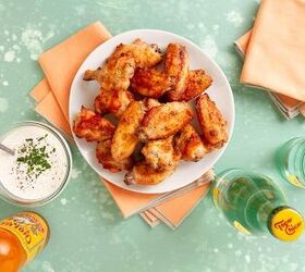 dry rub ranch chicken wings baked, white plate holding baked chicken wings next to white dipping sauce orange napkins and glass bottles