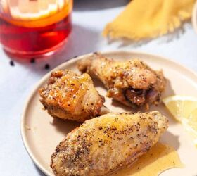 honey lemon pepper wings crispy baked, 3 baked chicken wings topped with honey on a beige plate