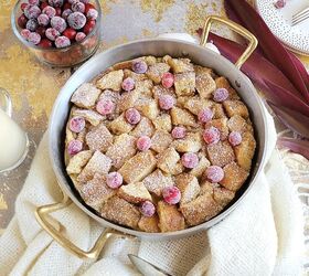 eggnog bundt cake, functional image eggnog bread pudding garnished with fresh cranberries top down photo bread pudding is in a round silver baking pan with gold handles there is a bowl of sugared cranberries and gold polka dot plates
