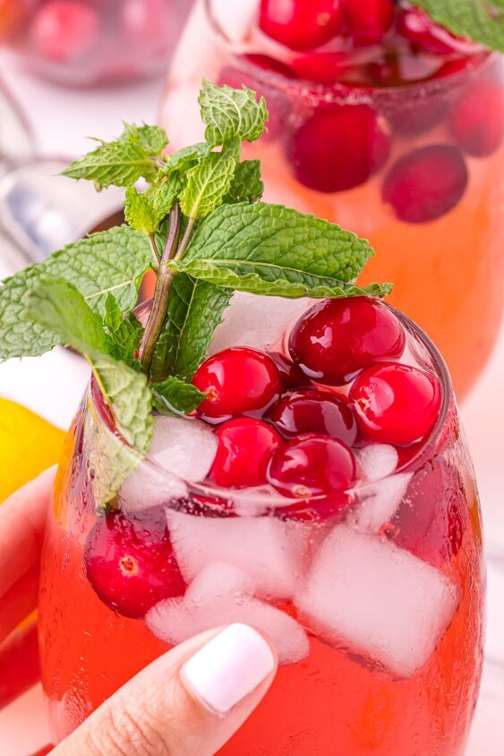 cranberry gin cocktail, Holding cranberry drink with mint cranberries and ice