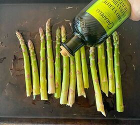 roasted asparagus with parmesan lemon, hand pouring olive oil onto baking sheet asparagus