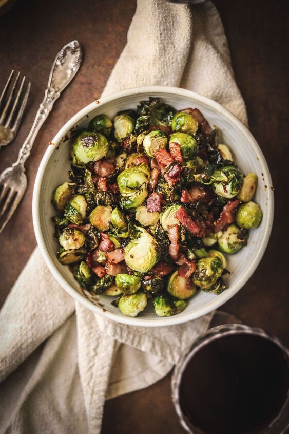 brussels sprouts with bacon, A bowl of raosted brussels sprouts with bacon and a glass of red wine