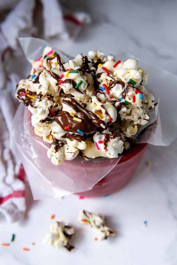 chocolate drizzled popcorn expert tips ideas, overhead shot of chocolate popcorn in a red container