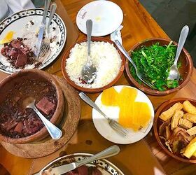 feijoada rice and beans brazilian style with meat, Table with feijoada orange slices kale yuka rice and other plates from Bolinha restaurant in Sao Paulo Brazil