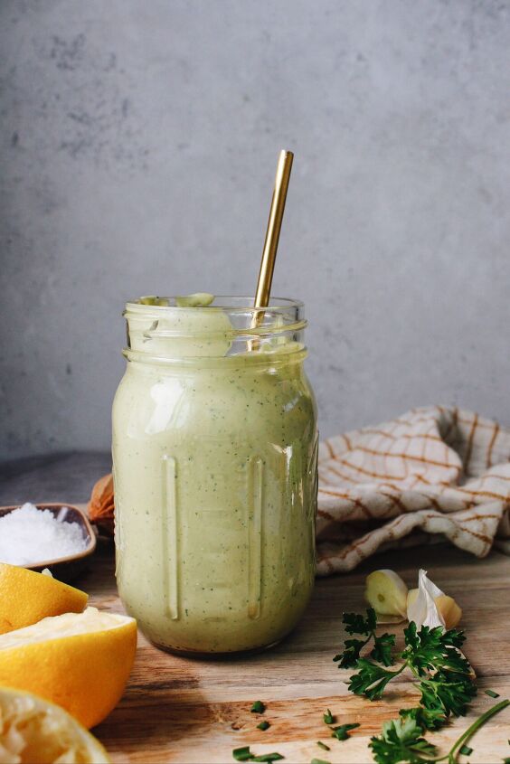 lemon herb tahini sauce, lemon herb tahini sauce in a jar surrounded by lemon parsley garlic