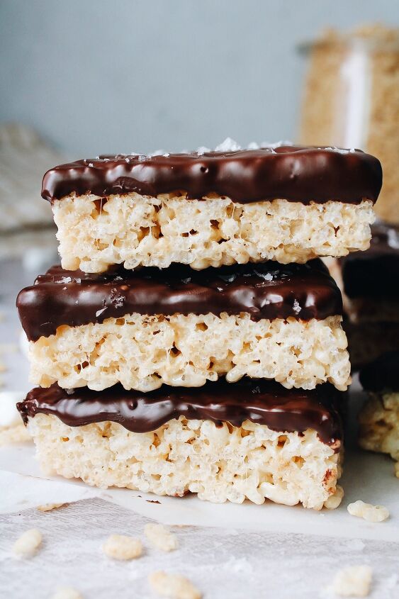 chocolate covered rice krispie treats, sideview chocolate covered rice krispie treats stacked on parchment paper