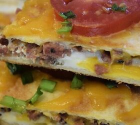 Two pieces of quesadilla with green onion and tomato on top and the words Sausage And Egg Breakfast Quesadillas digitally written on top