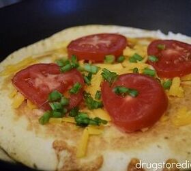 Tomatoes green onion and cheese on top of a pan