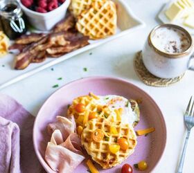 savory buttermilk cheddar belgian waffles, savory waffles on a pink plate next to fruit and a latte on a white background