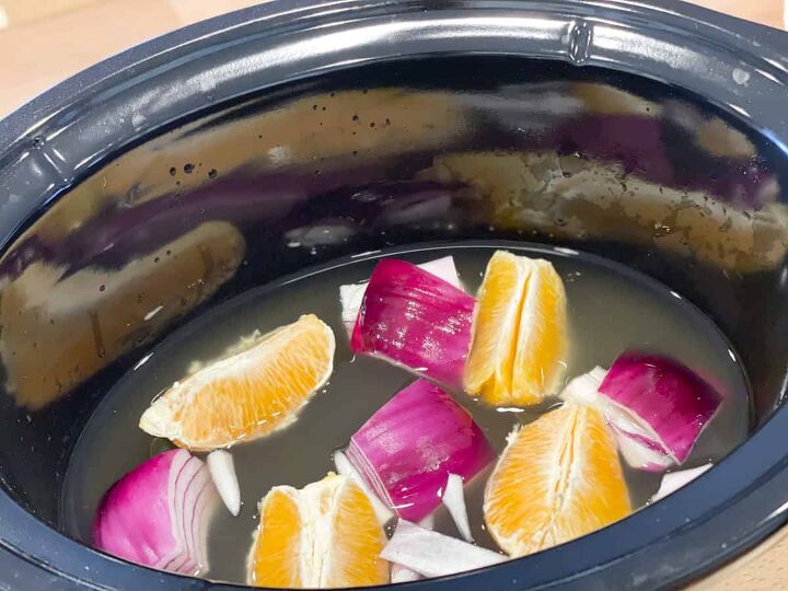 slow cooker orange chicken, orange sections onion quarters and chicken broth in crock pot