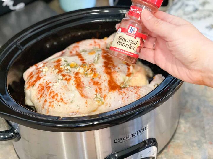 slow cooker orange chicken, sprinkling chicken in crock pot with smoked paprika