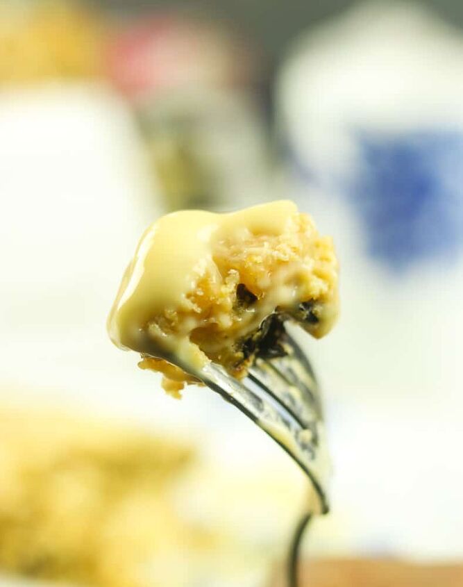 traditional spotted dick british steamed pudding, piece of Spotted Dick Pudding on a fork with Devon Custard