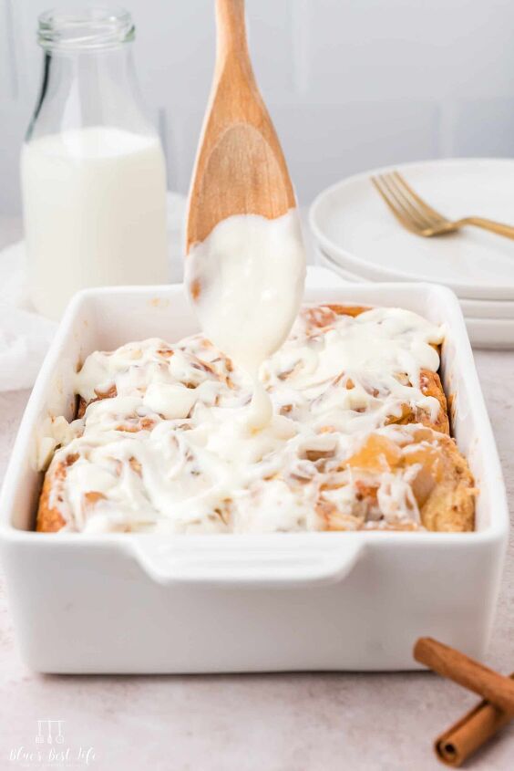 cinnamon rolls with apple pie filling, A spoon drizzling cream cheese frosting