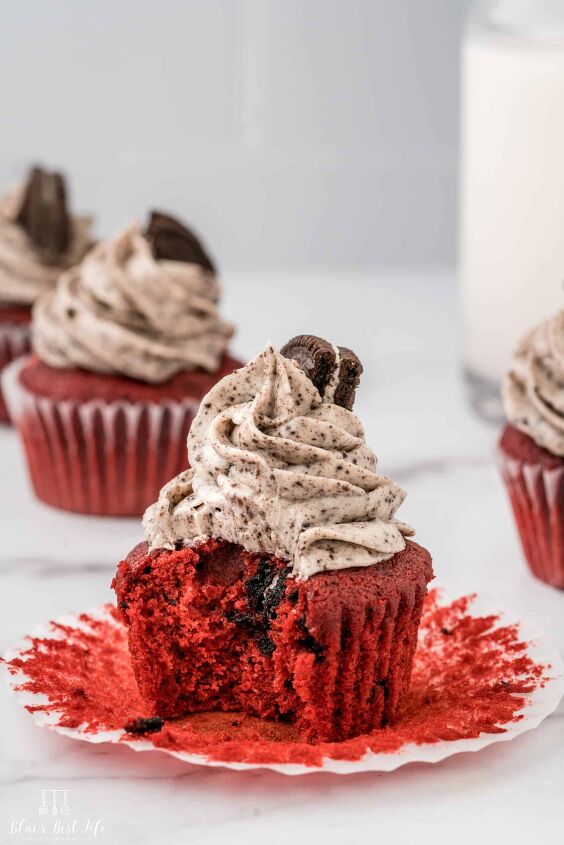 oreo red velvet cupcakes with oreo cream cheese frosting, A bite taken from a red velvet cupcake