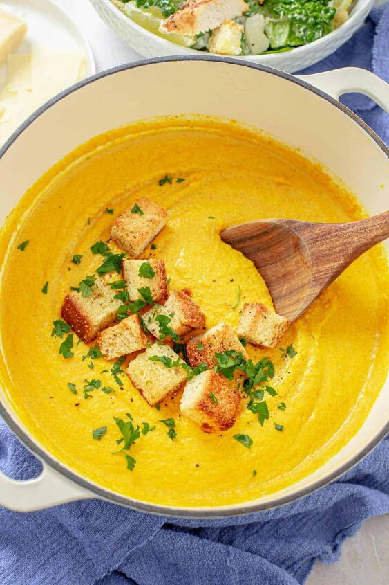 healing carrot ginger turmeric soup vegan, carrot ginger turmeric soup with croutons in a white pot