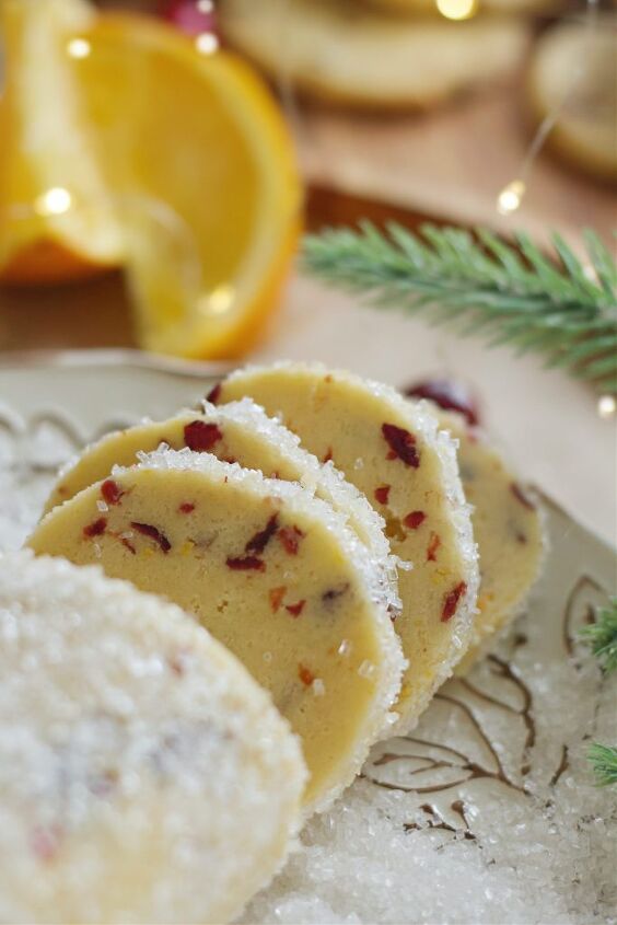 cranberry orange icebox cookies with orange zest drizzle, slices of cookie dough that was rolled in decorating sugar