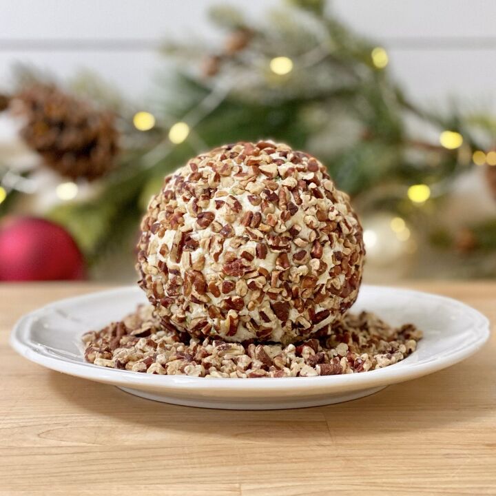 rudolph christmas cheese ball, Cheese ball rolled in toasted pecans on a white plate