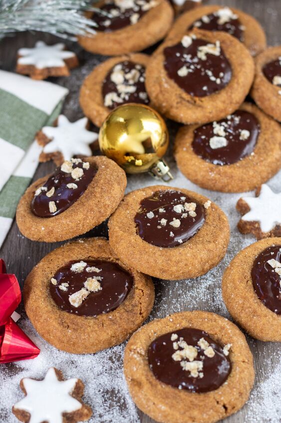 gingerbread mocha thumbprint cookies, A pile of chocolate thumbprint cookies There s sugar that looks like snow in the background with little star shaped frosted cookies and a small gold ornament