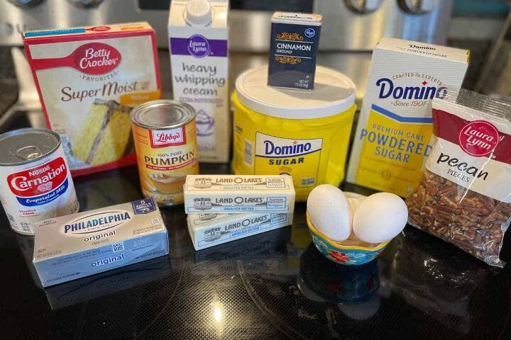pumpkin crunch cake with yellow cake mix, Ingredients for pumpkin crunch including eggs butter cream cheese evaporated milk cake mix heavy cream canned pumpkin cinnamon sugar powdered sugar and pecans
