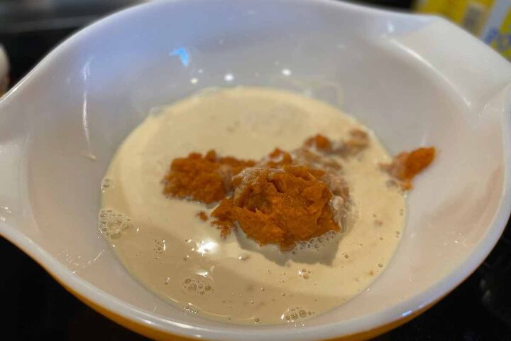 pumpkin crunch cake with yellow cake mix, mixing bowl with canned pumpkin and evaporated milk not yet mixed together