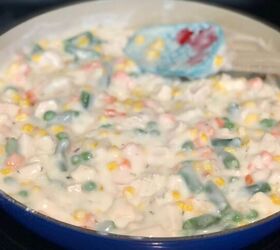 creamy cheddar chicken and biscuits casserole recipe, Chicken and biscuit filling mixture of vegetables and chicken in a blue cast iron braising pan