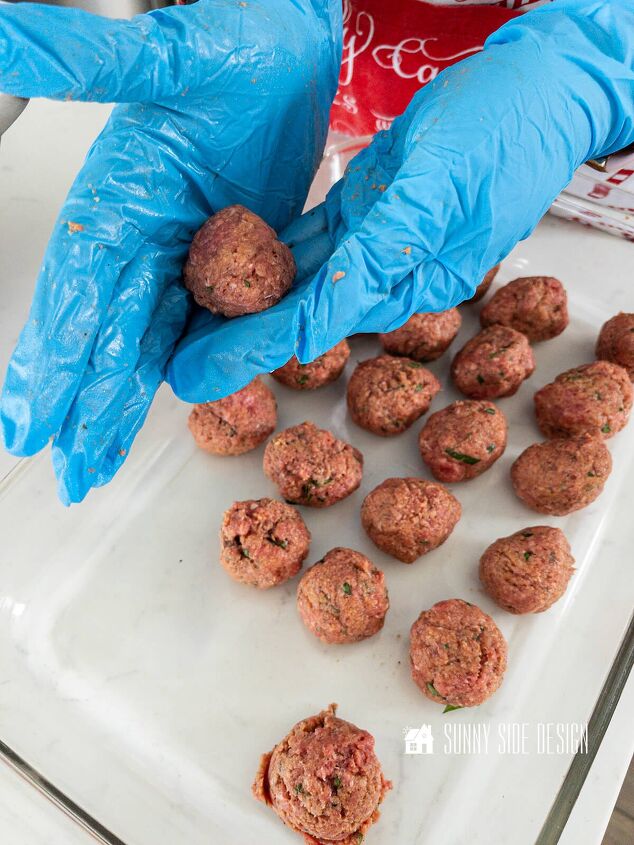 Meatball appetizer is formed into balls by hand and placed in a glass pan for baking