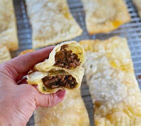 brazilian pastel recipe with beef filling, Hand holding two halves stacked of golden brown fried Pastel over sheet pan of more pasteis for traditional Brazilian Pastel Recipe with ground beef filling