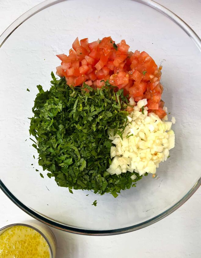 authentic lebanese taboule salad, onion tomato finely diced and finely sliced mint and parsley in a glass bowl
