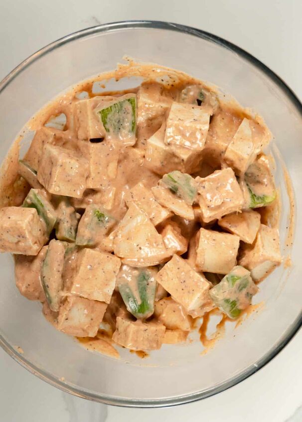 tofu skewers vegan shish tawook sandwich, cubes of tufu pieces of onion and pieces of capsicum in a pinkish sauce in a glass bowl