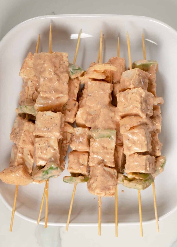 tofu skewers vegan shish tawook sandwich, uncooked tofu skewers in a white square plate