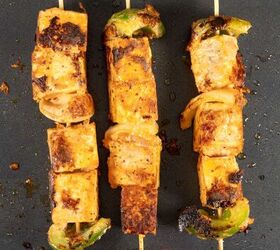 tofu skewers vegan shish tawook sandwich, three skewers with tofu cubes and vegetables on a grill